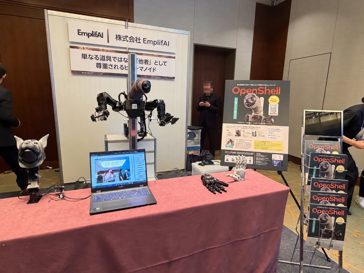 An OpenShell robot on display, with an expressive head and dual arms